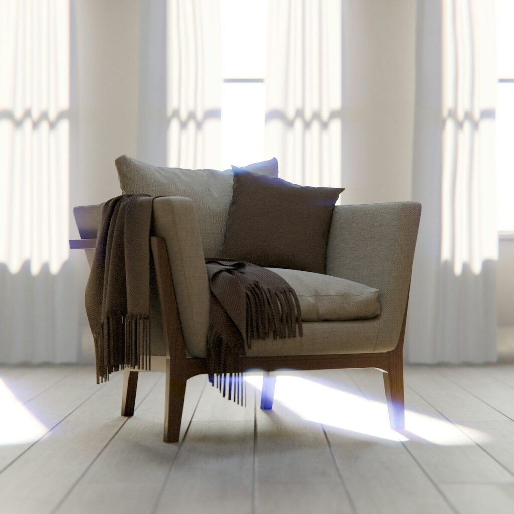 A comfortable armchair with blankets and pillows.
