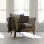 A comfortable armchair with blankets and pillows.